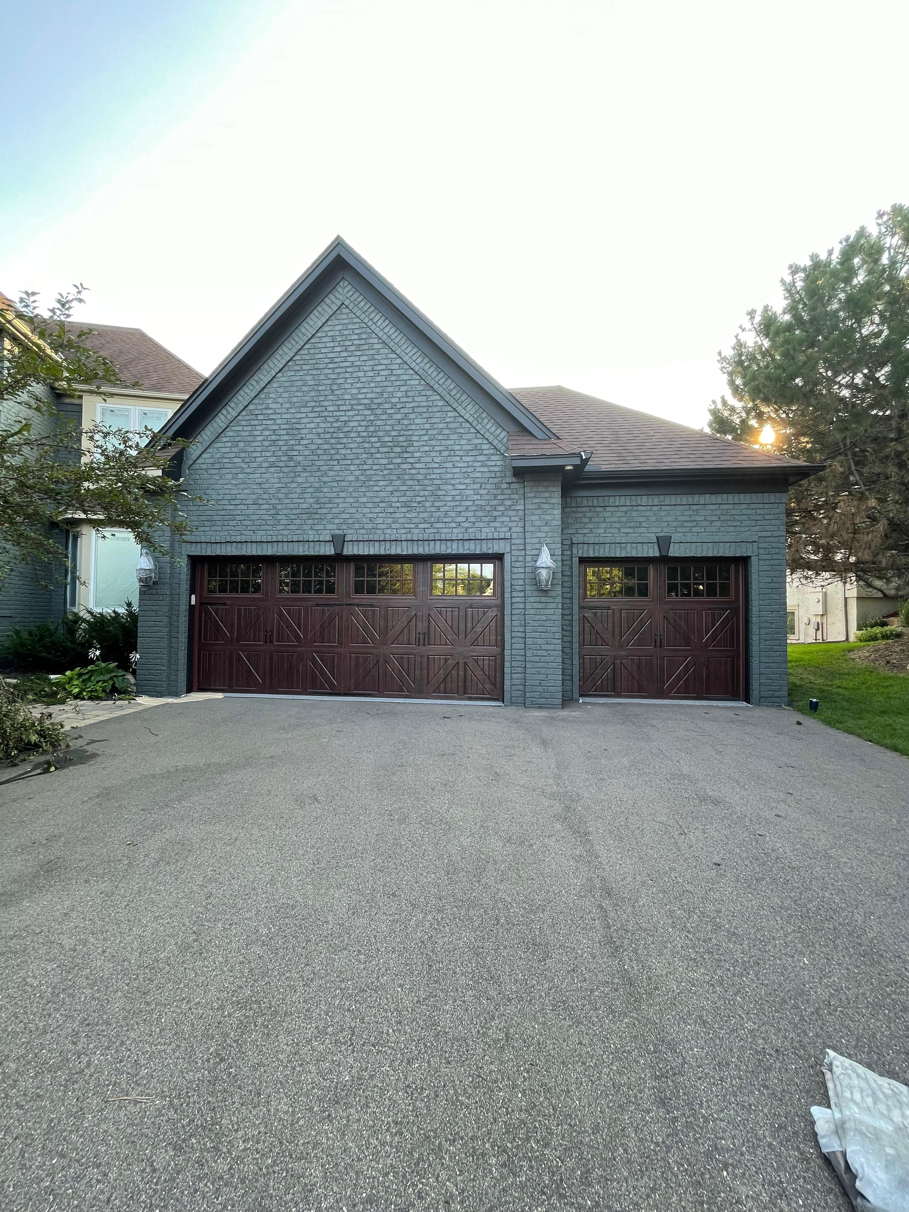 Gray painted brick home with garage doors